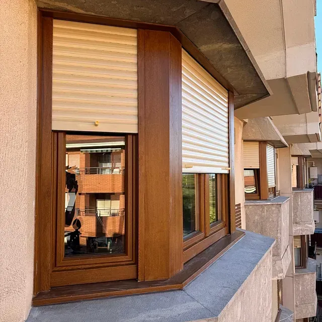 Una ventana con marco de madera y persianas blancas