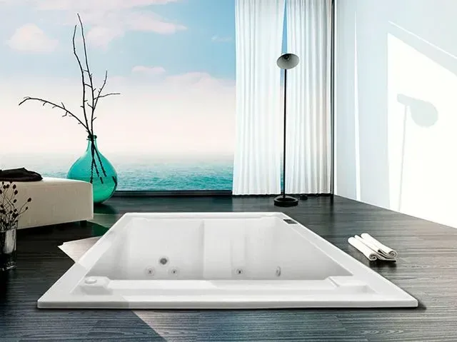 Una bañera en un baño con vista al mar.