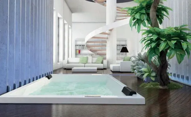 Una sala de estar con jacuzzi y una escalera de caracol.