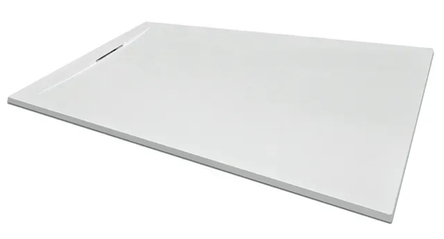 Un plato de ducha blanco está colocado encima de una superficie blanca.