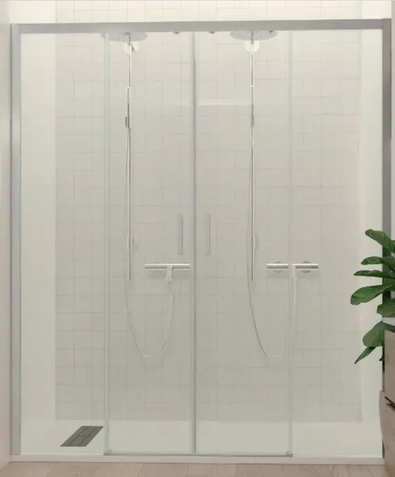 Un baño con una puerta de ducha corrediza de cristal.