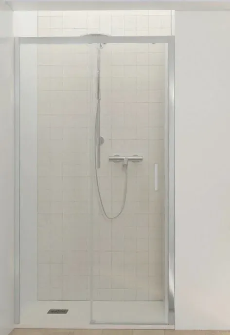 Una cabina de ducha con puerta corrediza de vidrio y cabezal de ducha.