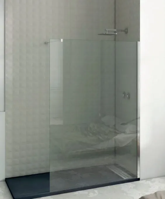 Un baño con ducha a ras de suelo y puerta de cristal transparente.