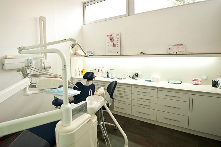 Un consultorio de dentista con un sillón dental y un escritorio.