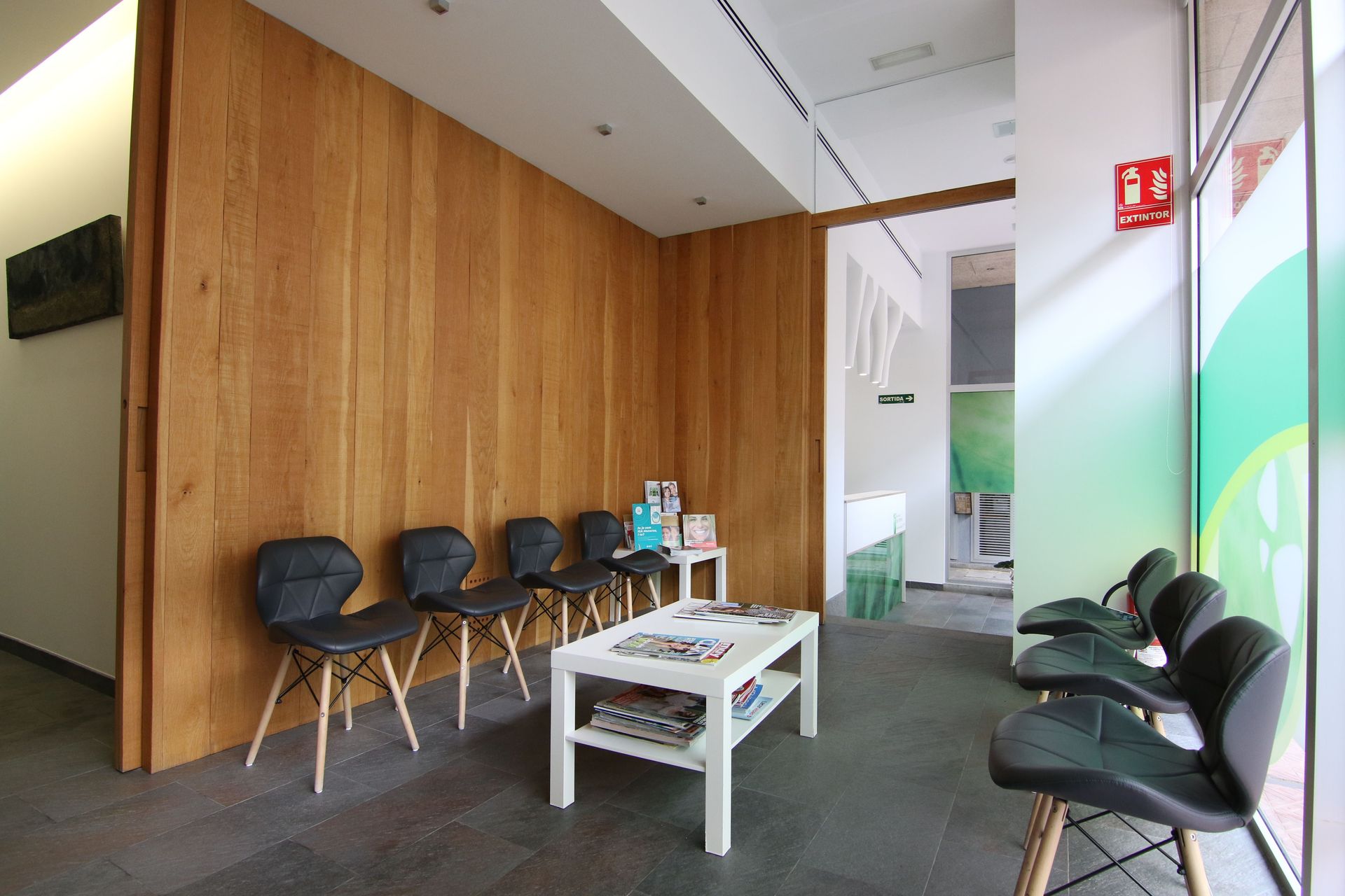 Una sala de espera con sillas y una mesa de café.