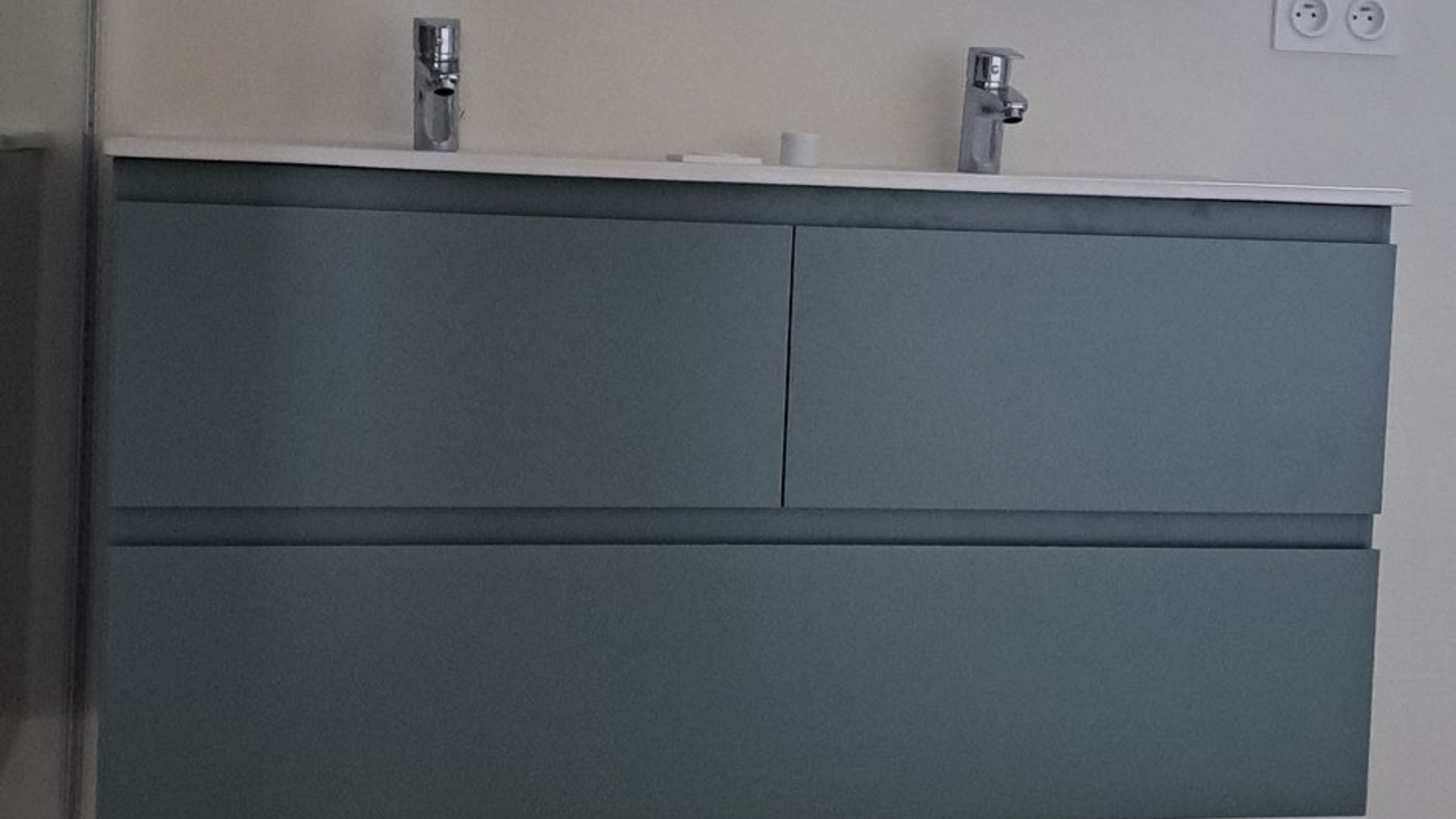 Meuble-lavabo gris avec deux lavabos et robinetterie argentée.