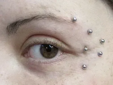 Un primer plano del ojo de una mujer con piercings.