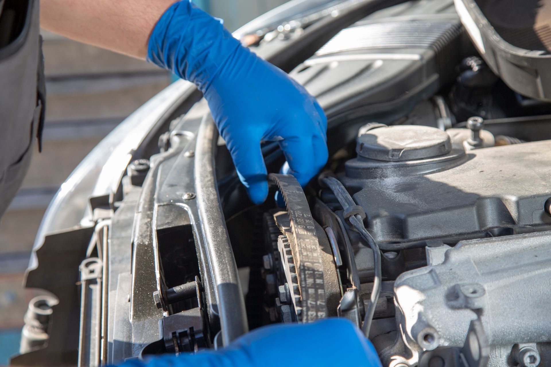 Dans un atelier de réparation automobile, deux mécaniciens inspectent le moteur d'un véhicule à l'aide d'un appareil de diagnostic et d'un ordinateur portable.