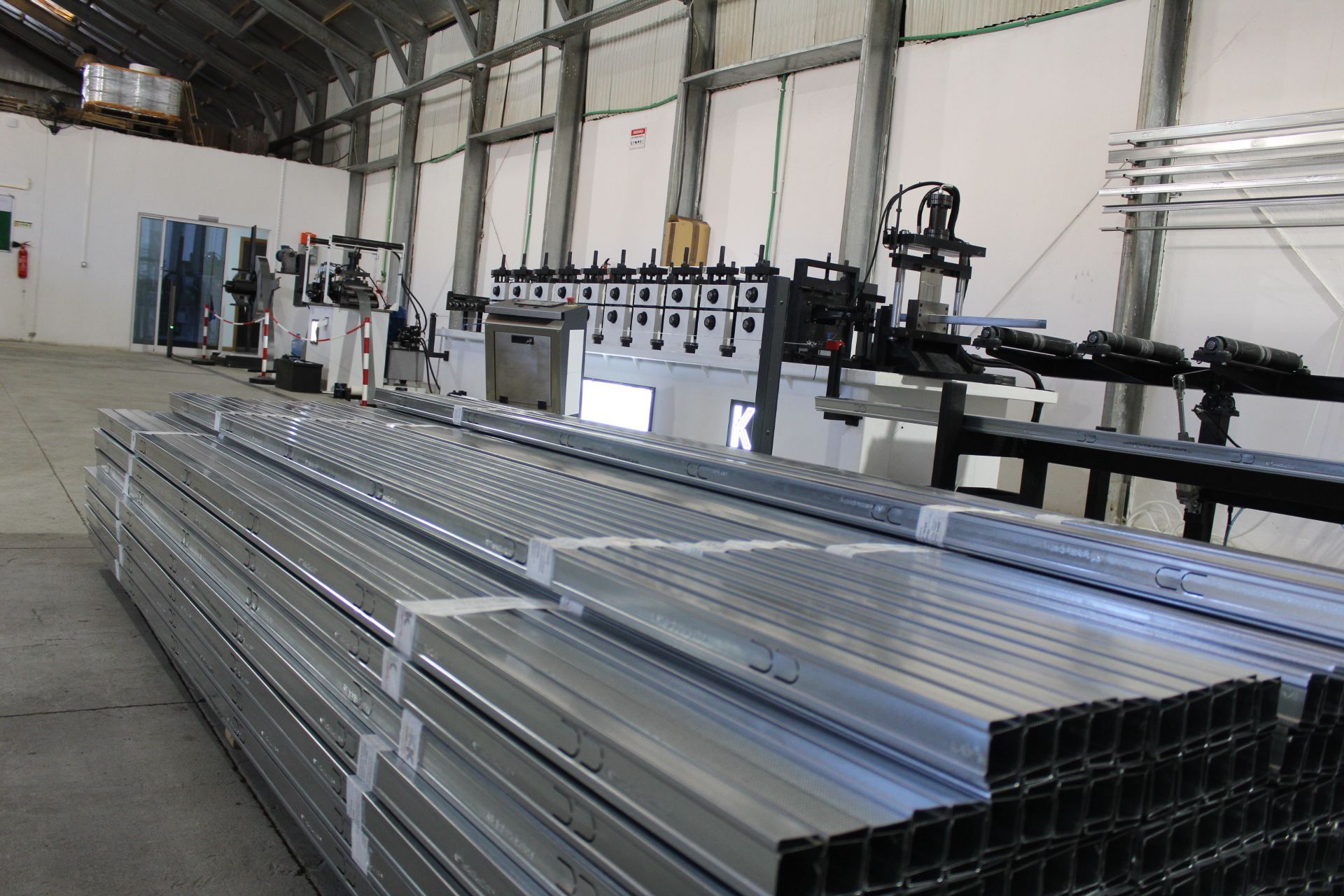 Uma sala vazia com paredes brancas e uma porta que leva a uma cozinha.