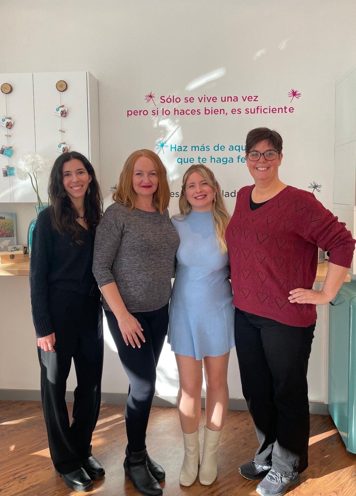 Un grupo de mujeres posan para una fotografía juntas en una habitación.