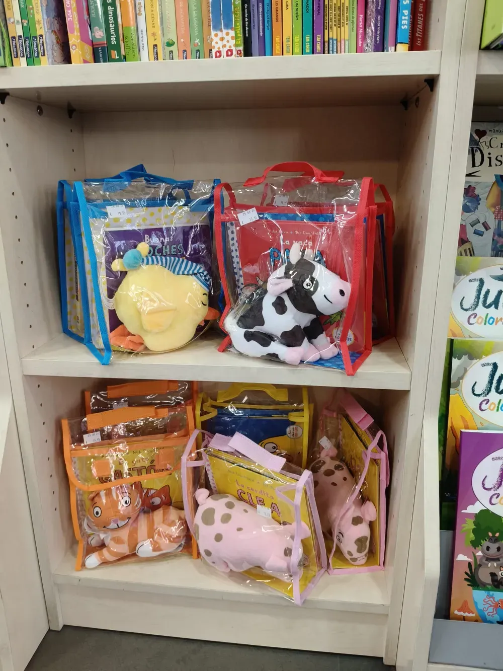 Bolsas coloridas de peluche en una estantería blanca de una tienda