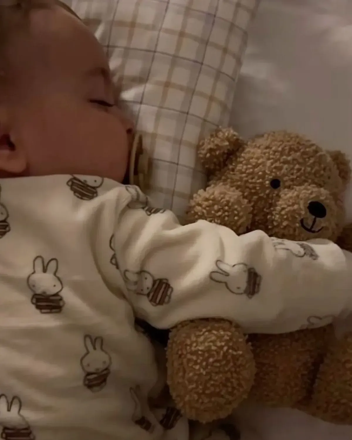Dos niños trepando una pared de escalada de madera, buscando presas de colores.