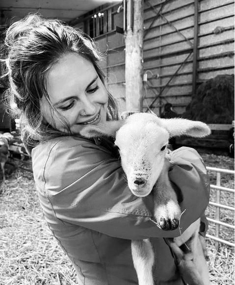 une femme tient une brebis