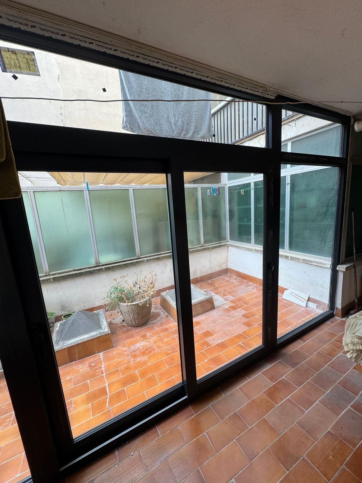 Pared con una abertura de doble ventana enmarcada en negro, que deja pasar la luz natural del exterior.