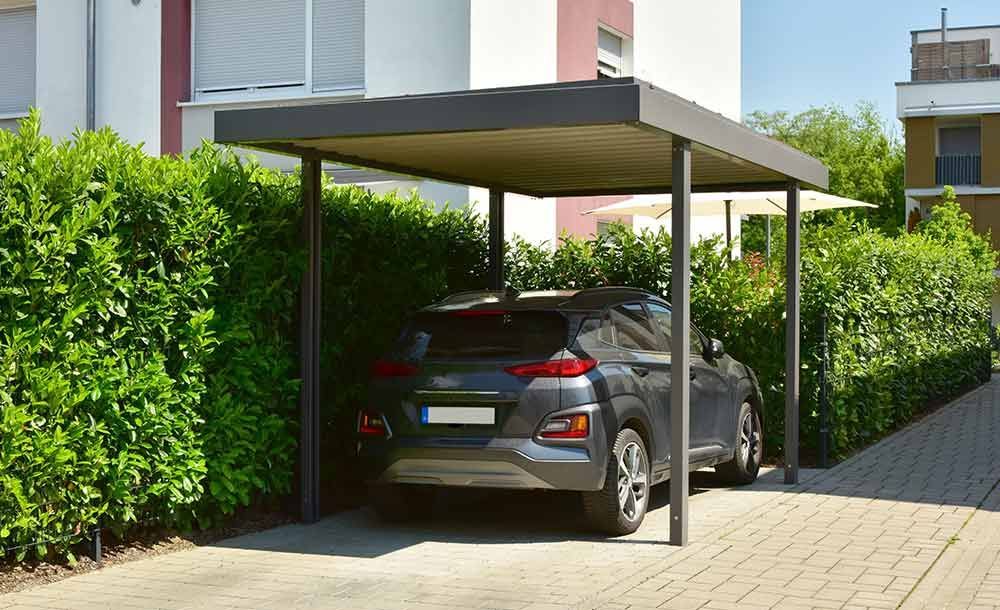 Ein Auto ist unter einem Carport vor einem Haus geparkt.