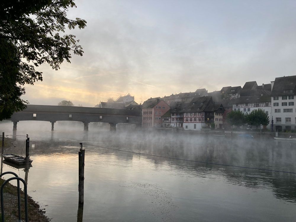 Eine Brücke über einen Fluss, aus dem Nebel aufsteigt