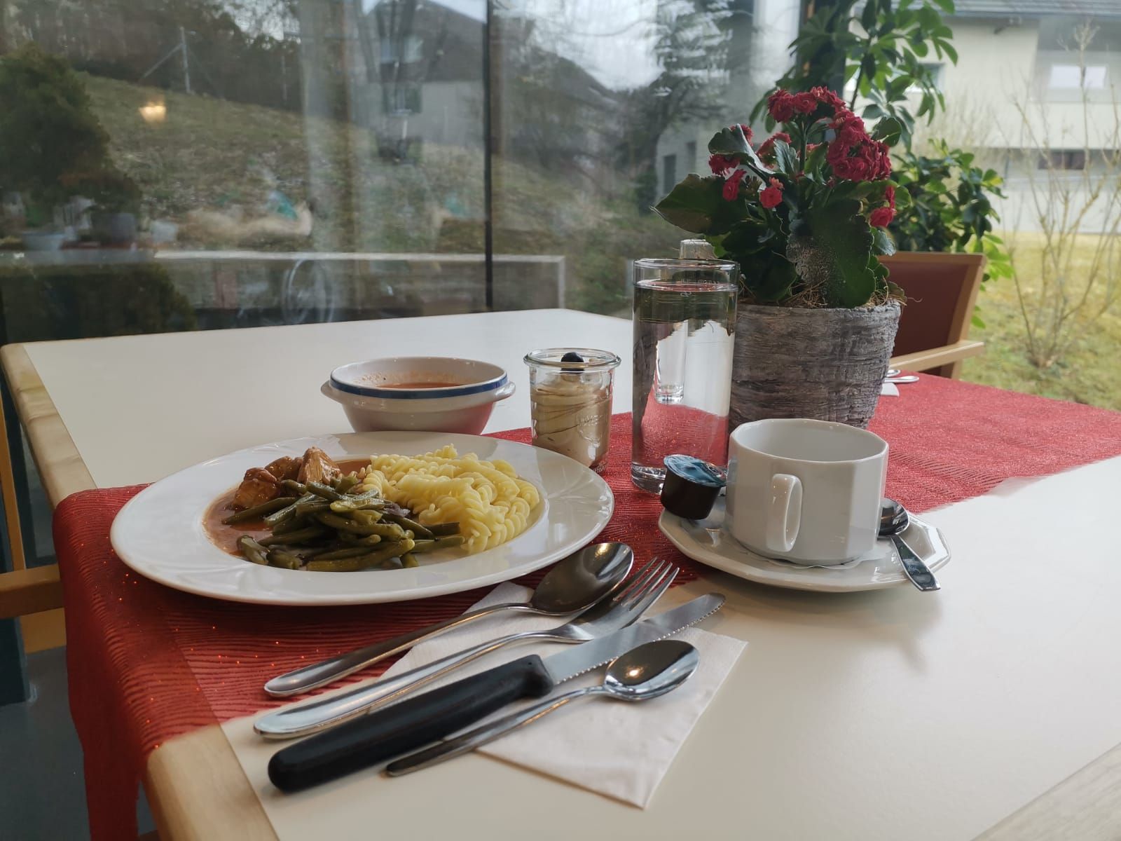 Ein Tisch mit einem Teller Essen und Besteck darauf.