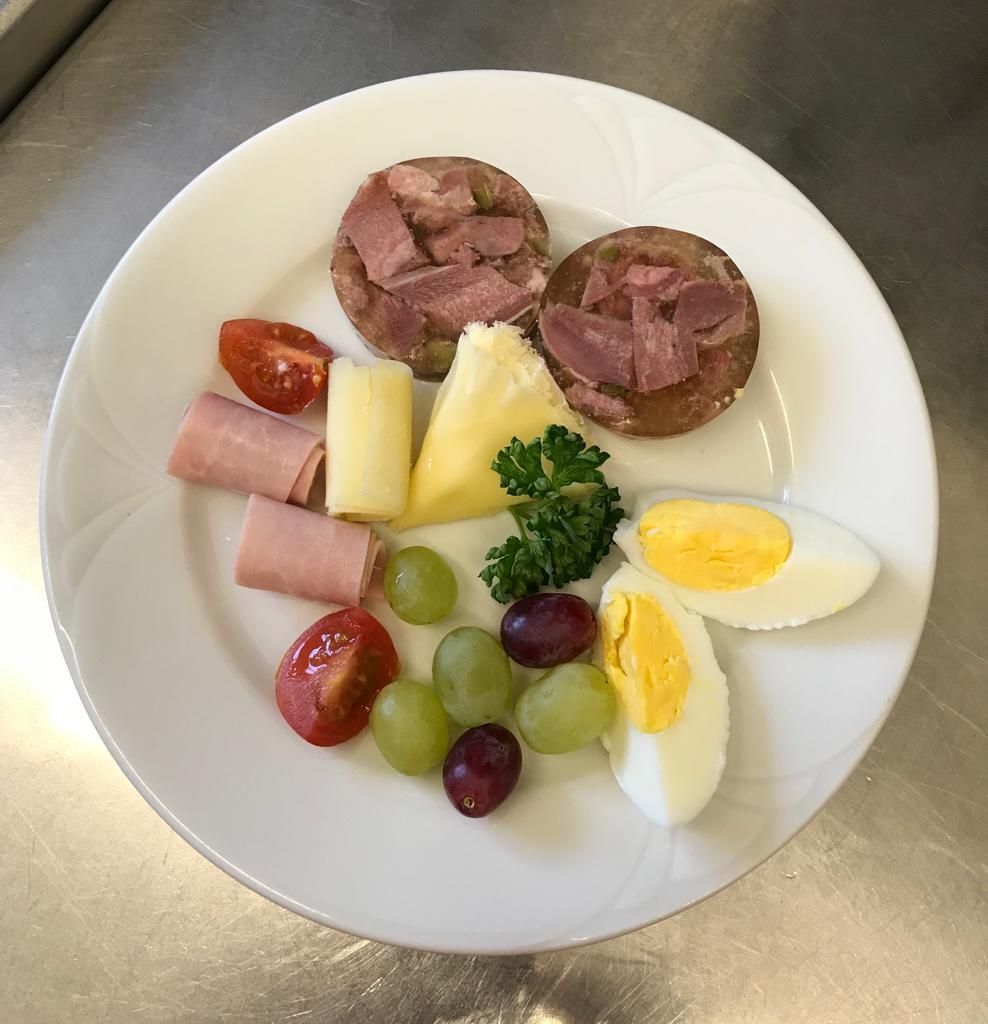 Ein weißer Teller mit Eiern, Tomaten und Trauben