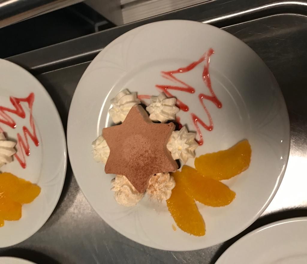 Ein weißer Teller mit einem sternförmigen Dessert darauf
