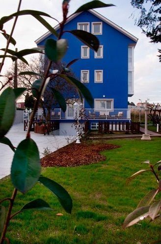 Una casa azul con césped delante