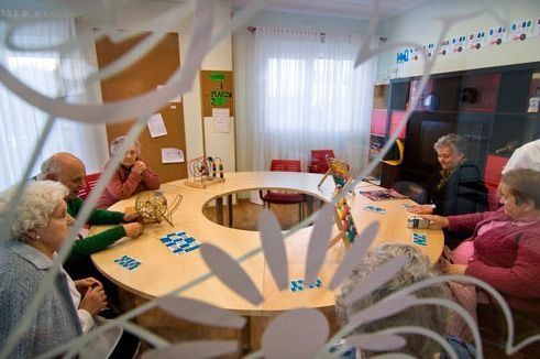 Un grupo de personas están sentadas alrededor de una mesa en una habitación.