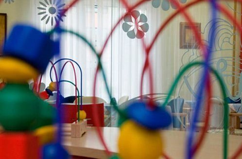 Una imagen borrosa de la habitación de un niño con juguetes y una mesa.