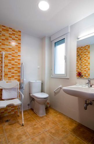 Un baño con inodoro, lavabo y silla.