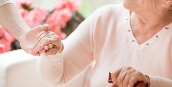 Una mujer sostiene la mano de otra mujer mientras está sentada en un sofá.