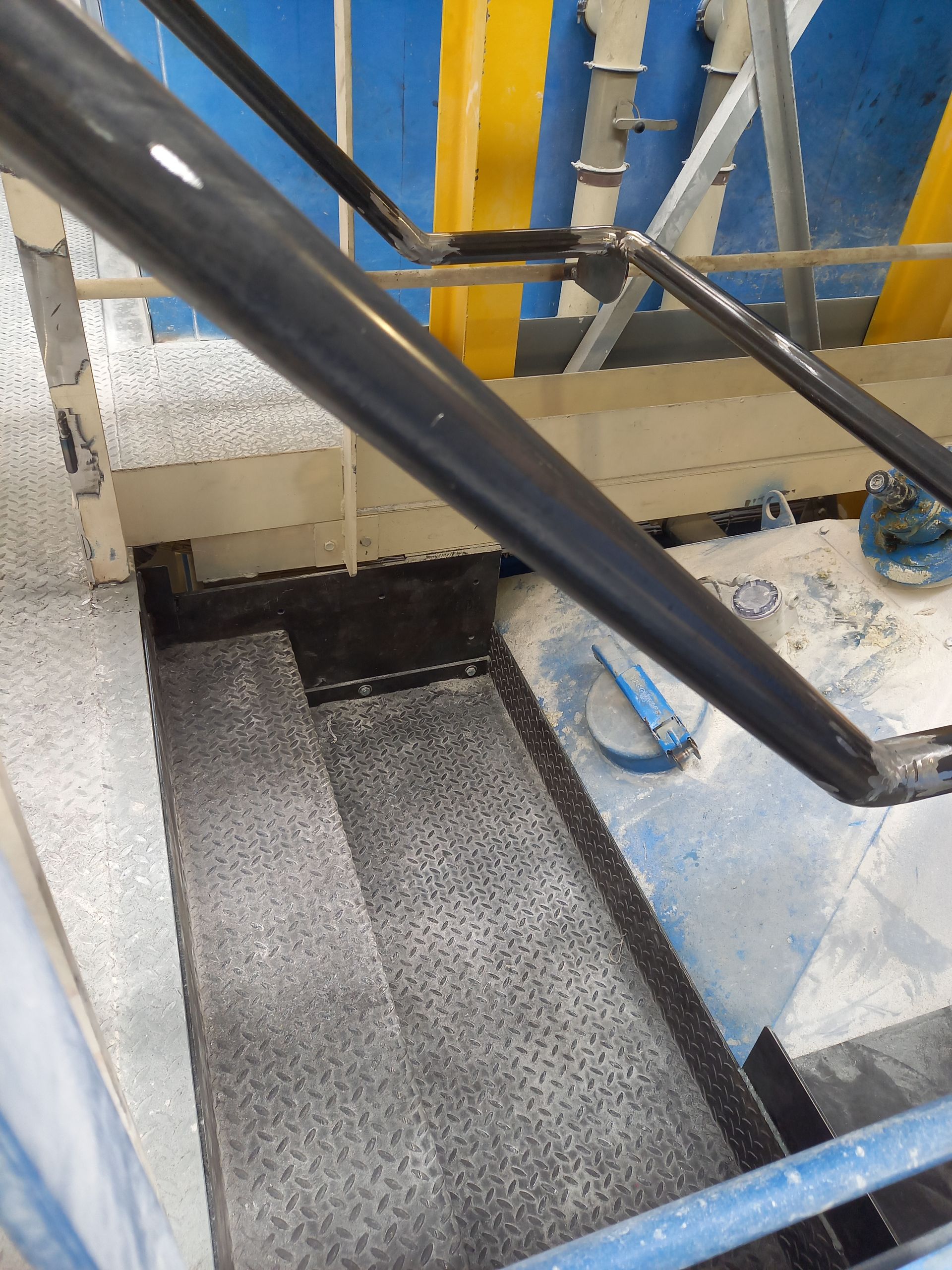 Escalier en métal avec rampe foncée dans un décor industriel.