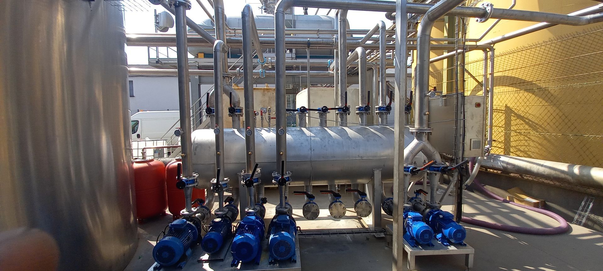 Tuyaux, pompes et réservoirs industriels en extérieur.