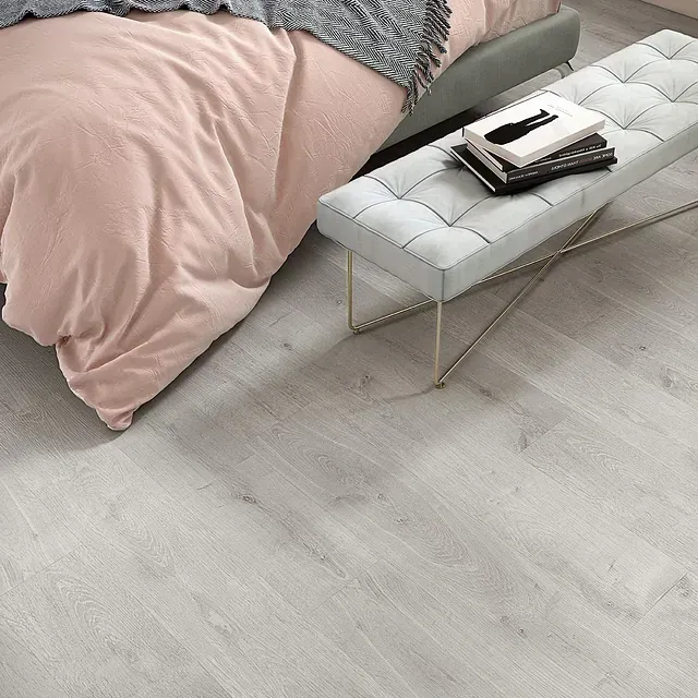 Un dormitorio con una cama y un banco con libros encima.