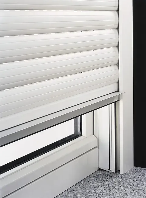 Un primer plano de una persiana blanca en una ventana.