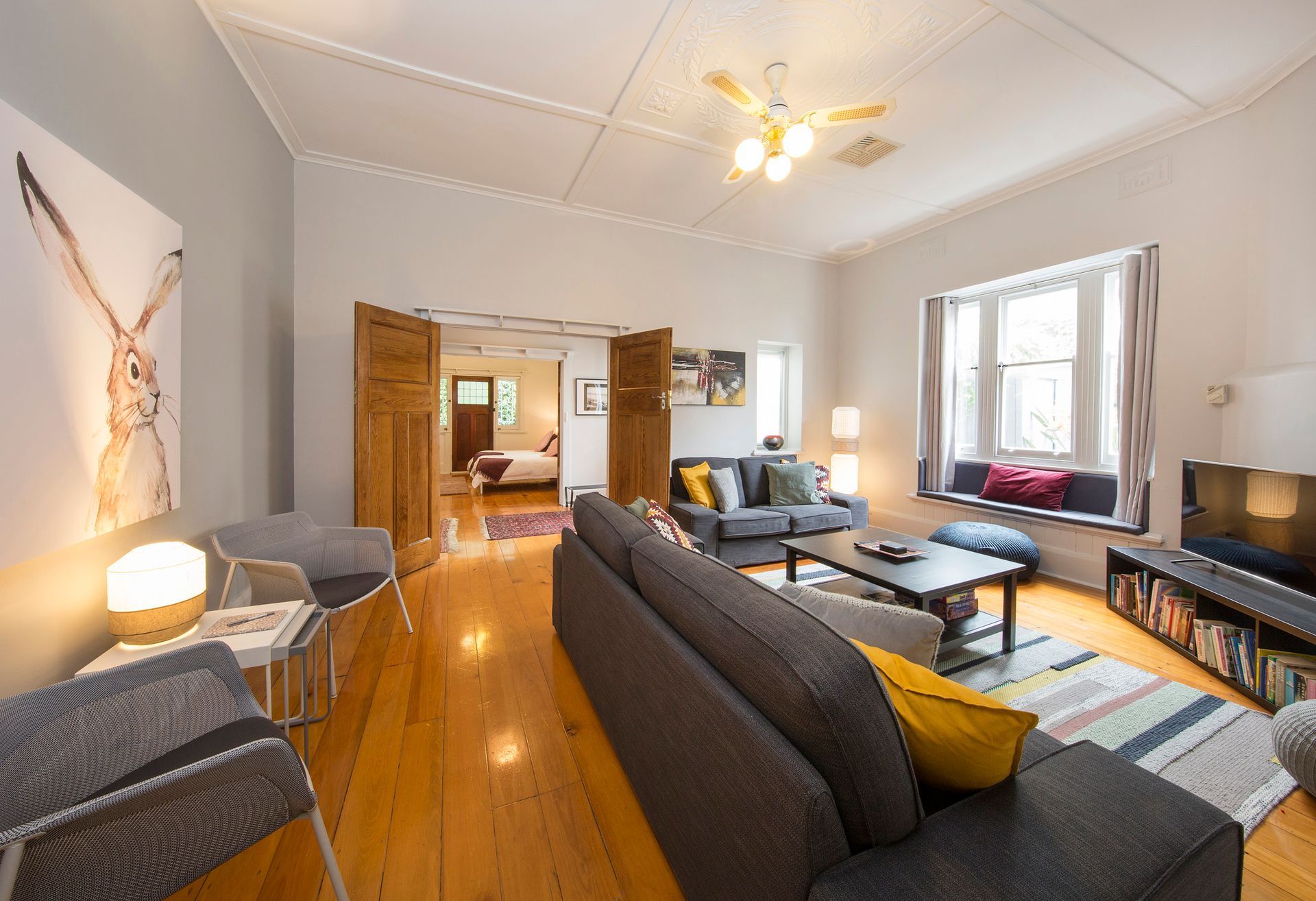 A wooden deck with a table and chairs under a pergola. Brighton, South Australia. 
