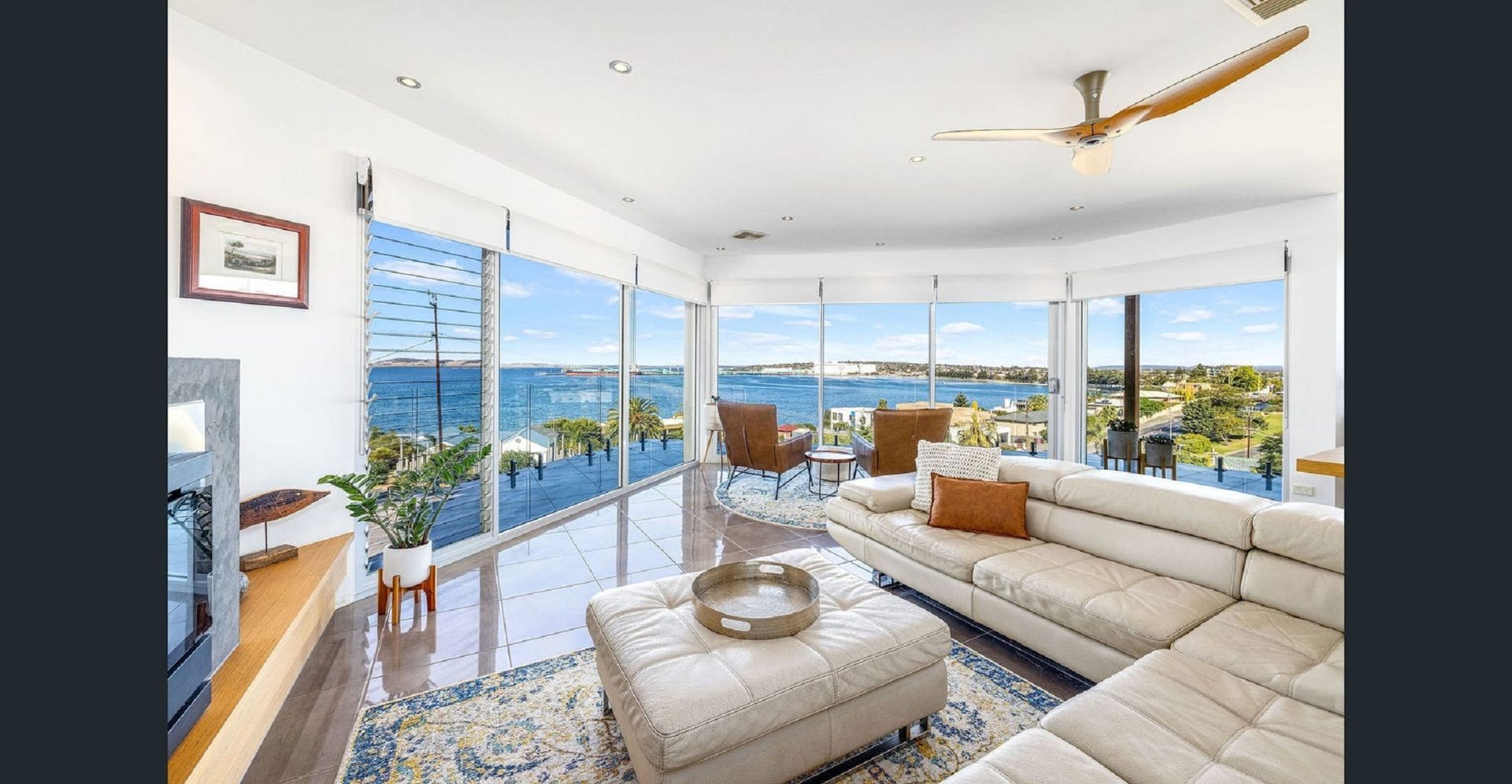 A living room with a couch and a view of the ocean. Port Lincoln, South Australia. 