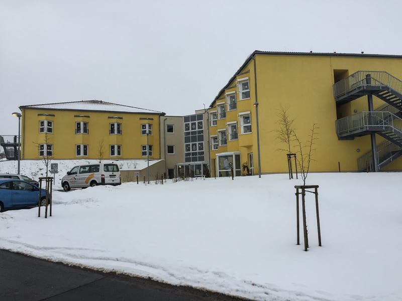 Ein großes gelbes Gebäude mit Treppen ist von Schnee umgeben