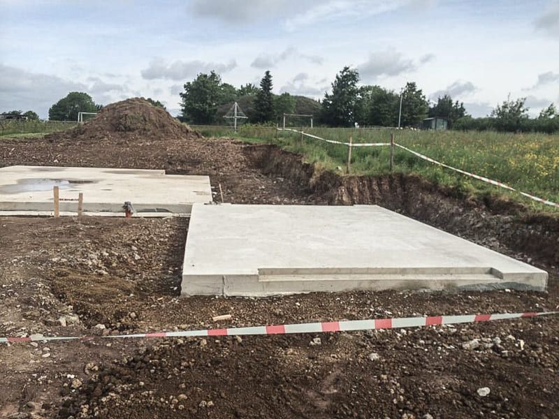 Eine Betonplatte liegt mitten auf einem Feld.