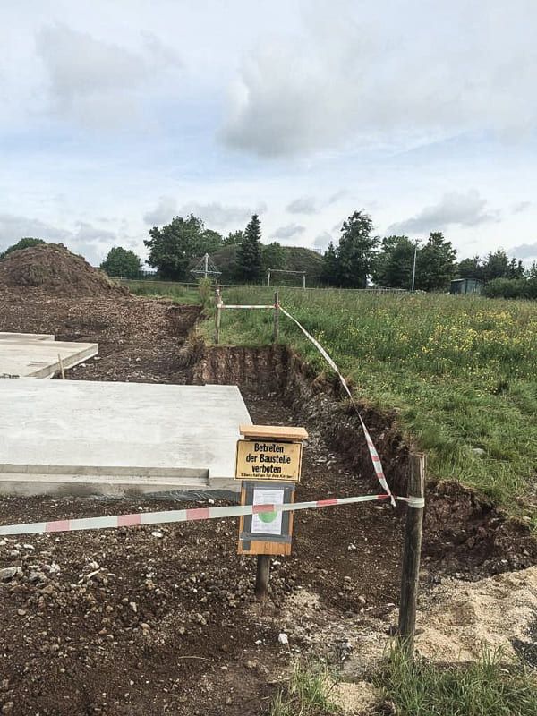 Eine Baustelle mit einem Schild am Straßenrand.