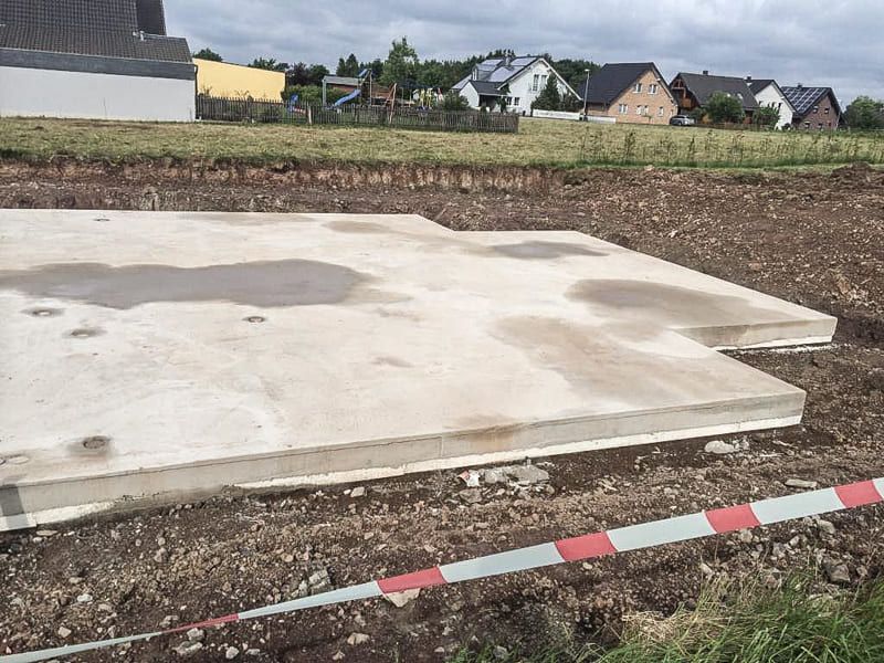 Eine große Betonplatte liegt auf einem Erdfeld.