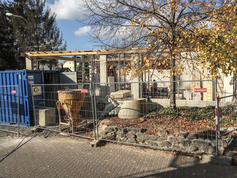 Eine Baustelle mit einem Zaun darum und einem im Bau befindlichen Gebäude.