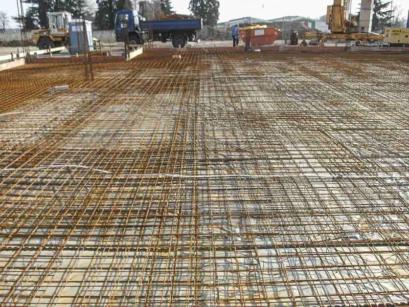 Ein Betonboden wird gebaut, im Hintergrund ist ein LKW zu sehen.