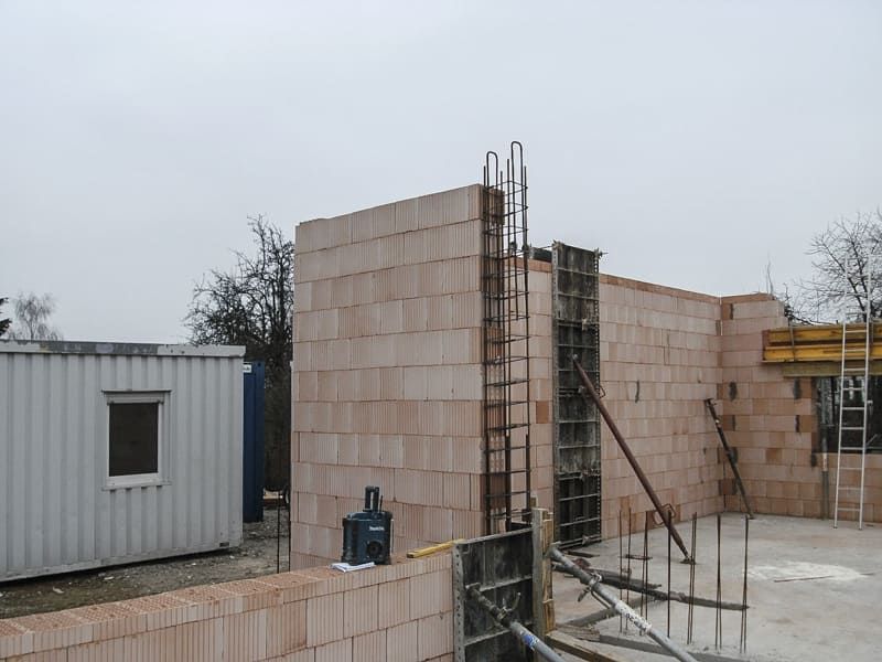 Auf einer Baustelle wird eine Ziegelmauer errichtet