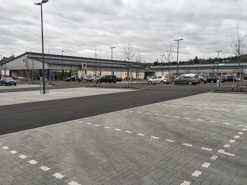 Ein Parkplatz mit vor einem Gebäude geparkten Autos