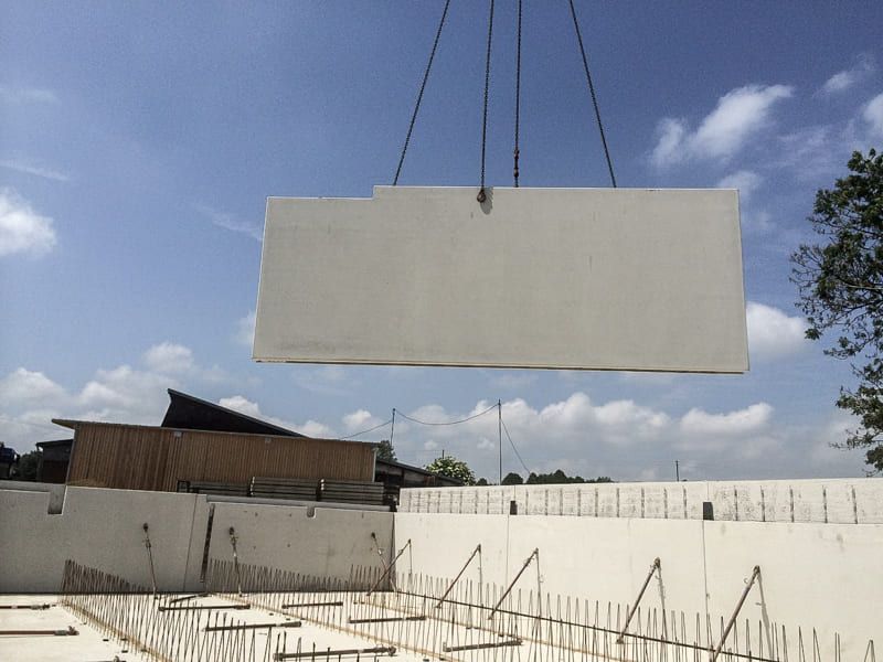 Ein großes Stück Beton wird von einem Kran angehoben.