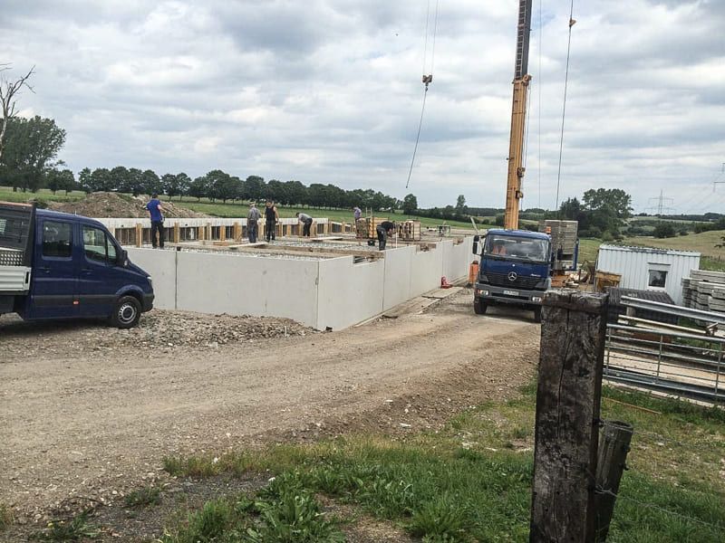 Ein blauer Lieferwagen steht vor einer Baustelle.