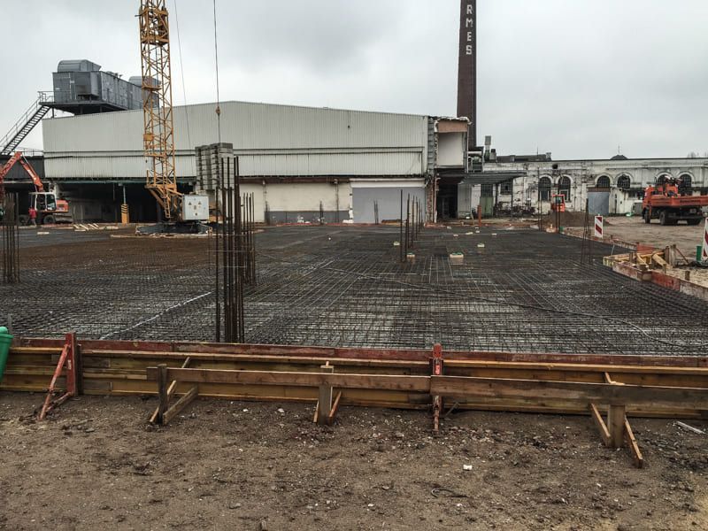 Eine Baustelle mit einem großen Gebäude im Hintergrund