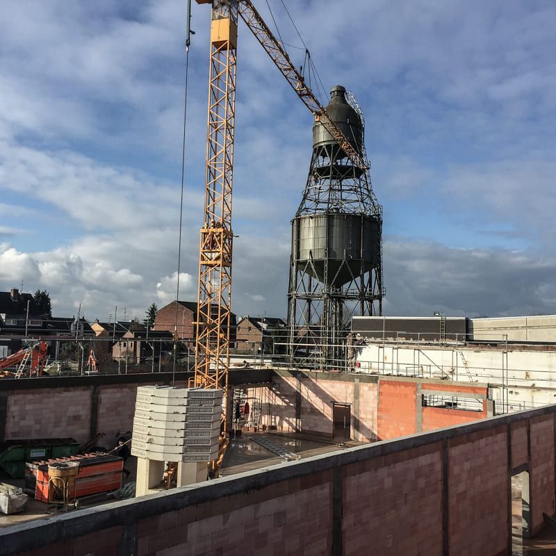 Eine Baustelle mit einem Kran und Silos im Hintergrund