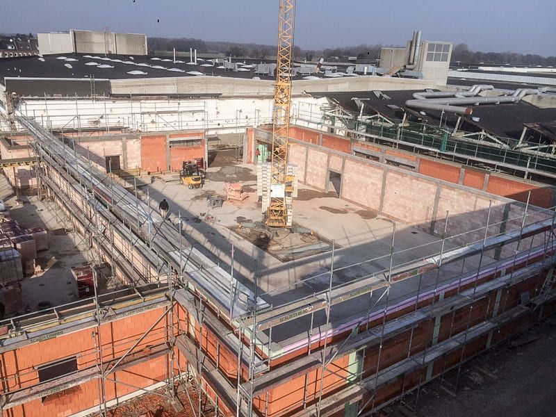 Eine Luftaufnahme einer Baustelle mit Gerüst und Kran.