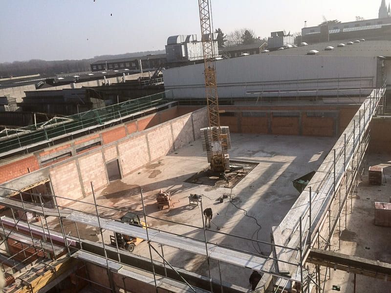 Eine Luftaufnahme einer Baustelle mit Gerüst und Kran.