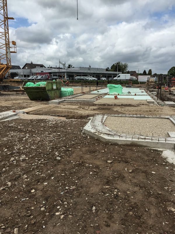 Eine Baustelle mit einem grünen Müllcontainer in der Mitte