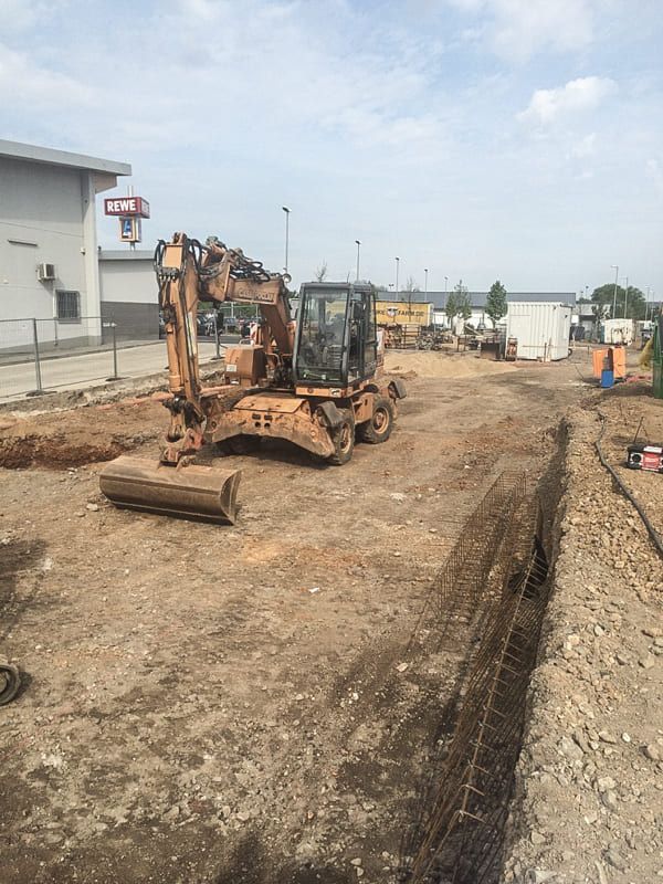 Ein großer Bagger arbeitet auf einer unbefestigten Straße